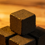 Tumpukan briket arang batok kelapa kualitas ekspor hasil produksi Indonesian charcoal briquette supplier profesional di pabrik.