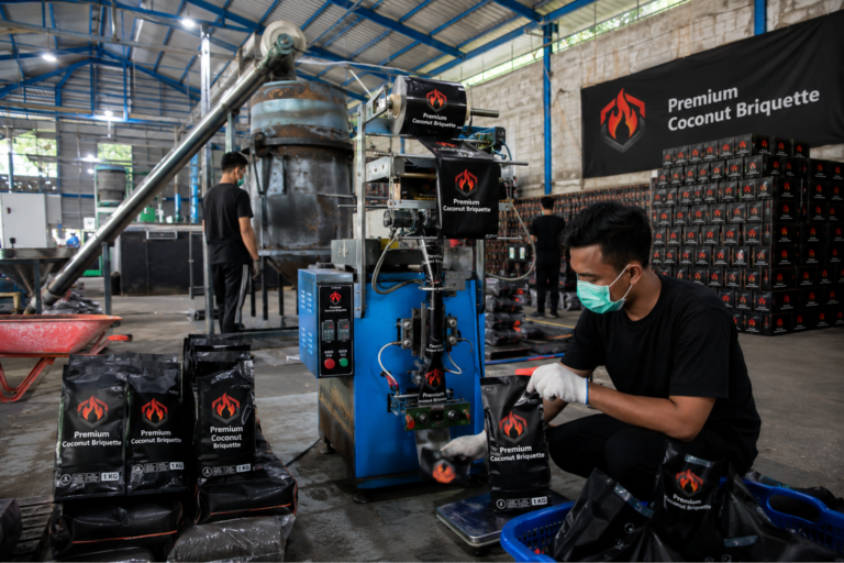 Proses pengemasan briket batok kelapa kualitas tinggi di pabrik modern.